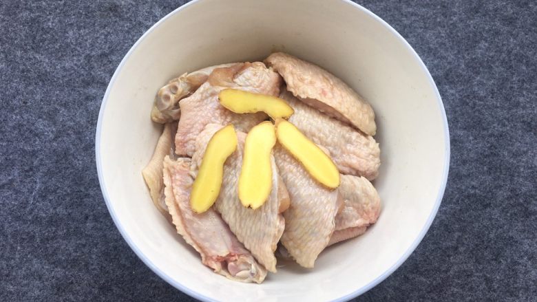 盐焗鸡中翅～烤箱版,姜片一起放入盘中，用手揉搓一会，把调料均匀涂抹在鸡中翅上。
