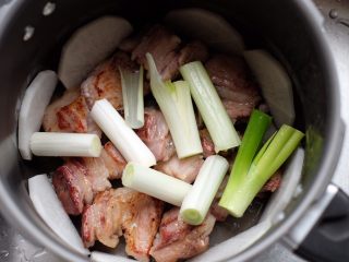 【再添一碗饭】の炖肉盖饭,四周铺上萝卜块，中间放上大葱段和其他香料