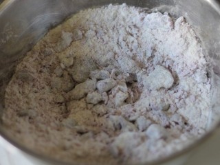 紫薯开花馒头,150克的面粉加入100克的紫薯泥，
用筷子搅拌成絮状。