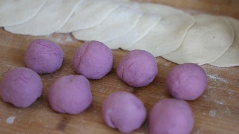 紫薯开花馒头,将紫色的剂子揉成圆团，
白色的剂子擀成面饼。