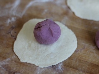 紫薯开花馒头,将紫色面团光滑面向下放置在白色面饼上。
