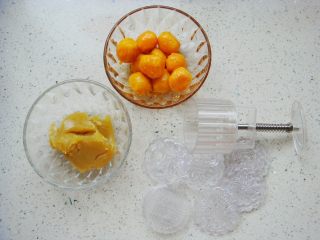 莲蓉蛋黄冰皮月饼,烤好的蛋黄，适量的莲蓉馅，月饼模具备用。（图中为：法焙客75克月饼模具）