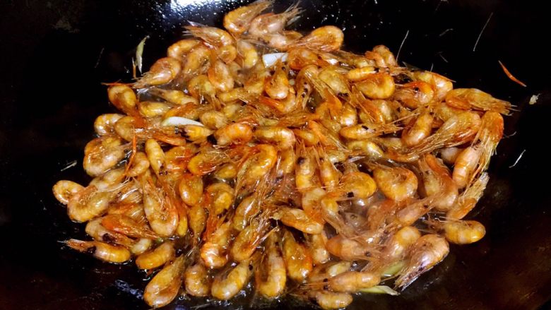 油爆小河虾,倒入炸好的小河虾，炒匀。