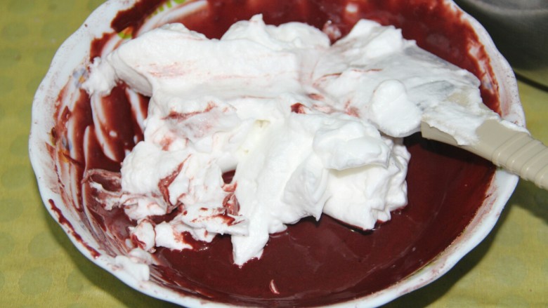 红丝绒戚风蛋糕,把三分之一的打发好的蛋清。混合到蛋黄和面粉溶液中，用橡皮刮刀搅拌均匀，要用翻拌的手法