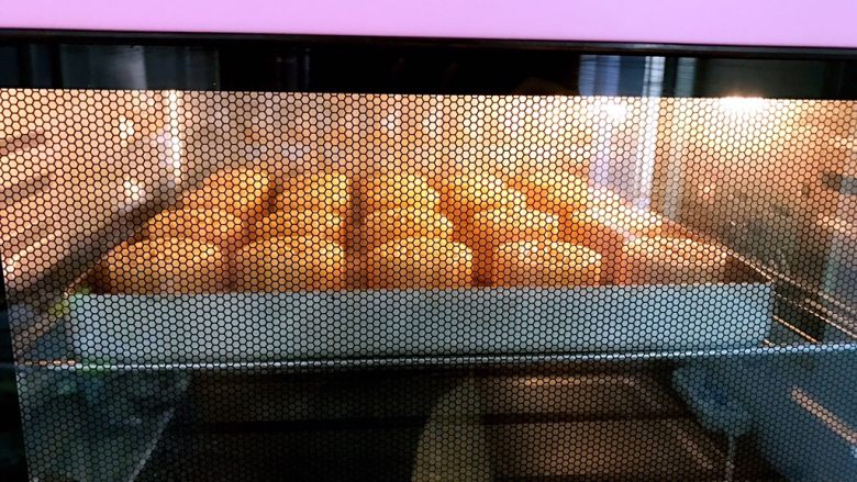 广式低糖莲蓉蛋黄月饼,放入预热好的烤箱里200度中层烤5分钟定型后取出月饼刷蛋黄水，这时烤箱转180度