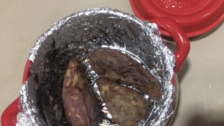 坤博砂锅烤红薯,注意砂锅不烫手后再取出红薯。