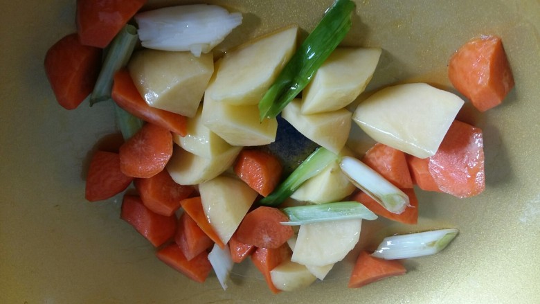 土豆胡萝卜丸子焖饭,倒入胡萝卜块和土豆块翻炒2分钟。
