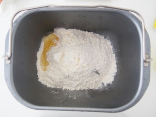 红苋汁麻花面包,将面粉加入面包机桶中，在角落里磕入一个鸡蛋