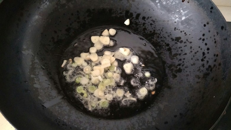 油菜炒香菇,锅里放油加热，放入蒜片和葱花炒香