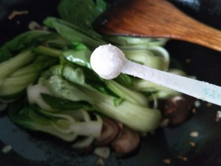 油菜炒香菇,接着加一小勺的盐继续翻炒