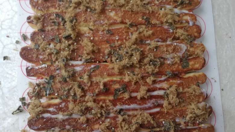 海苔肉松面包卷,烤好的面包倒过来，抹上一层<a style='color:red;display:inline-block;' href='/shicai/ 4856'>沙拉酱</a>，撒上肉松和海苔碎，然后将面包卷起来，切成大小合适的块。