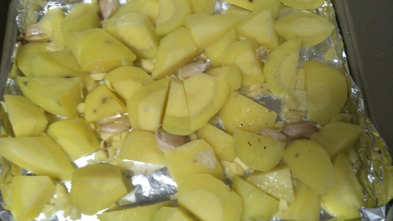 蒜香烤土豆,大蒜一半剥皮切碎，一般拍一下，放入土豆中，翻滚下