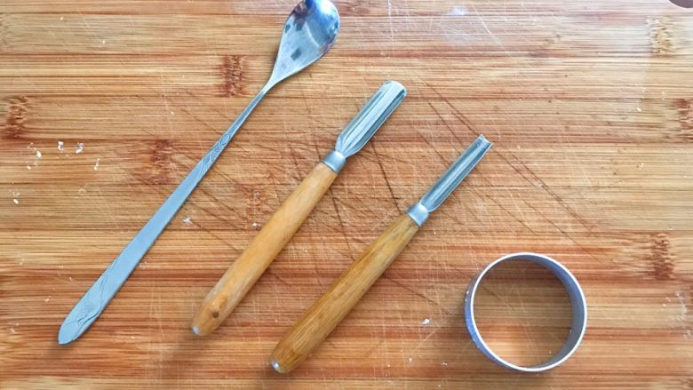 萌脸土豆饼,中间的两把是雕刻刀，如果没有就用左边的勺子柄