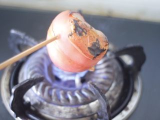 私房红烩牛腩，一碗吃不够,这里给大家解锁一个番茄去皮小窍门，看图，直接放在火上烧到皮都裂开。