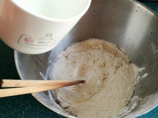 茴香鸡蛋花边菜饼,面粉里加入开水，一边加水一边用筷子搅拌。