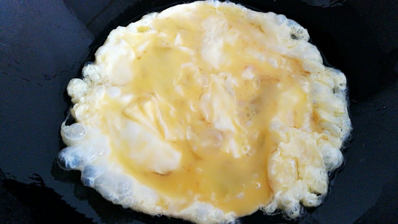 茴香鸡蛋花边菜饼,炒锅放油，开小火，倒入鸡蛋翻炒。