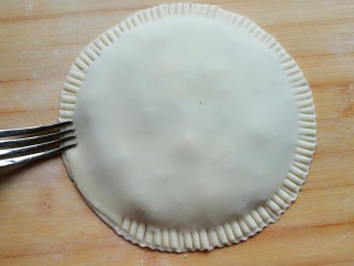 茴香鸡蛋花边菜饼,用叉子在饼皮四周按压出纹路。