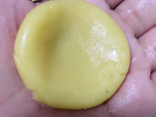 广式月饼——莲蓉蛋黄馅,分割饼皮15g一个，将饼皮用大拇指把中间压扁。