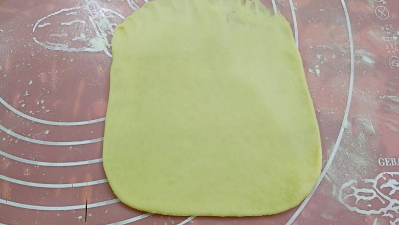 椰蓉麻花面包,取一个松弛好的小面团，轻拍排气后，用擀面杖擀成约5毫米厚的大致的方形，最上端压薄。