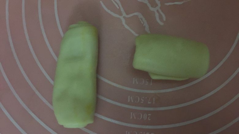 #甜食#酥掉渣的红豆蛋黄酥,继续取卷好的油皮，像左边那样按扁，再用擀面杖轻轻擀成长舌形，从上而下卷起（右边）