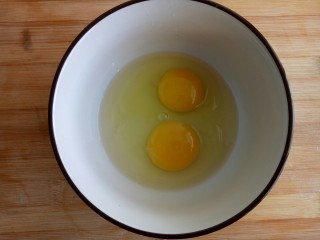 西红柿鸡蛋炒饭,鸡蛋打入碗中。
