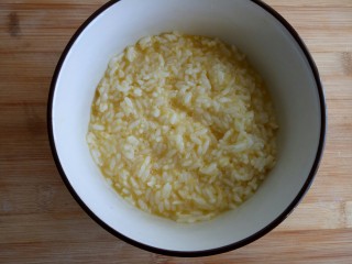 西红柿鸡蛋炒饭,把剩饭放入蛋液中，搅拌均匀。不能有成团的饭粒。