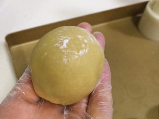 蔓越莓椰蓉月饼,取一个包好馅料的小圆球，搓成圆柱状，表面拍上少许干面粉。