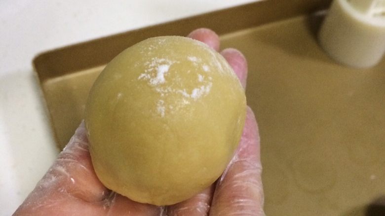 蔓越莓椰蓉月饼,取一个包好馅料的小圆球，搓成圆柱状，表面拍上少许干面粉。