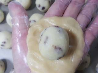 椰蓉枸杞月饼,16.取一份饼皮压扁后包入一份椰蓉馅。