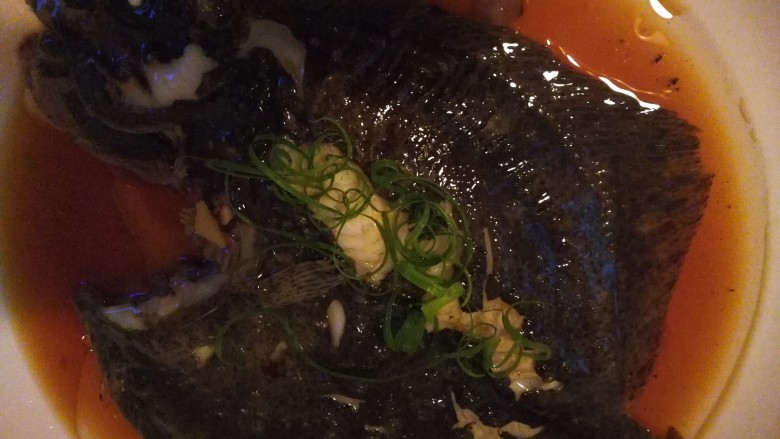 清蒸多宝鱼,蒸好后将鱼移到大盘里点缀上葱花卷，因为鱼大锅小，只能先用小盘子蒸熟再移。