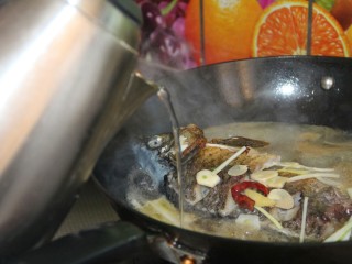家常炖鲫鱼,再加入适量的热水，继续盖盖子炖十分钟大火收汁