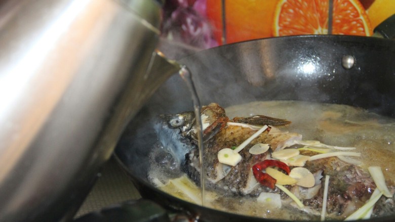 家常炖鲫鱼,再加入适量的热水，继续盖盖子炖十分钟大火收汁
