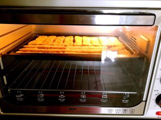 最爱面包＋酥脆椰蓉土司条,把烤盘放进预热好的烤箱里，上火170W，下火200W，烤15分钟，取出烤盘，面包条翻面。再把烤盘放入烤箱，上火100W，下火120W烤13分钟即可。
