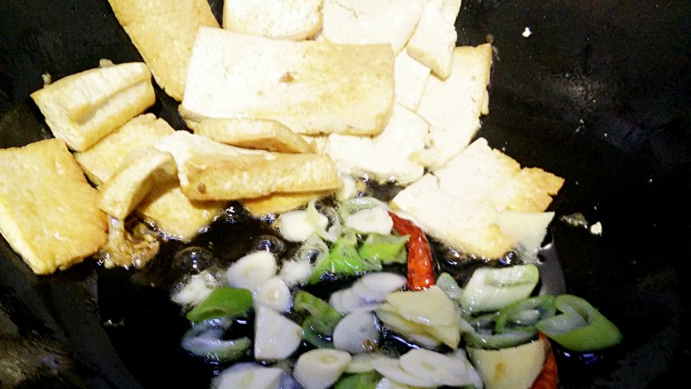 小黄鱼焖豆腐,放入葱姜蒜干辣椒等作料爆香。再放入煎好豆腐和小黄鱼，在到入调好的料汁，凉水闷煮1到二分钟左右即可出锅。
