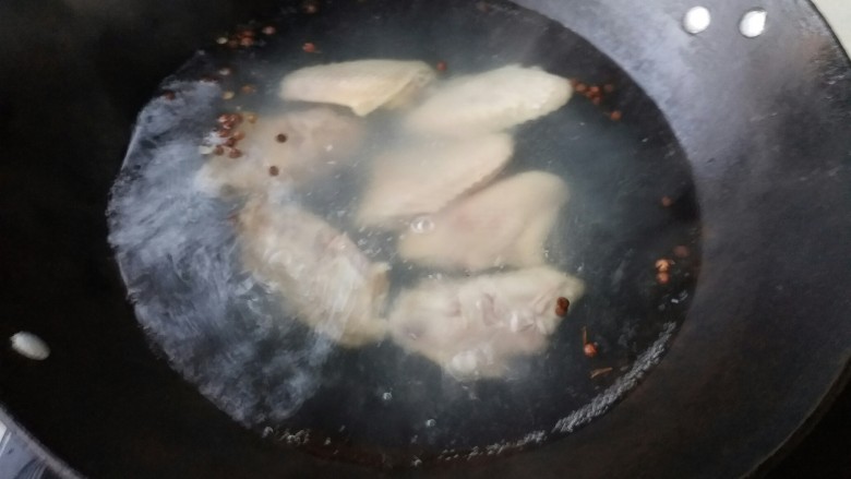 红烧鸡翅莲藕,炒锅坐炉具上倒入清水，放入鸡翅在放入花椒去腥，开水焯3分钟即可捞出