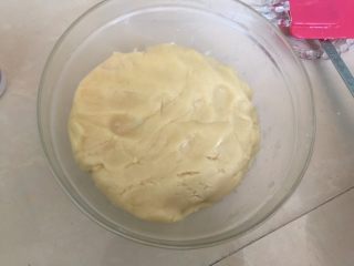 广式蛋黄红豆沙月饼,利用刮刀刮拌均匀，做好的饼皮盖上保鲜膜放入冰箱冷藏1～2个小时
