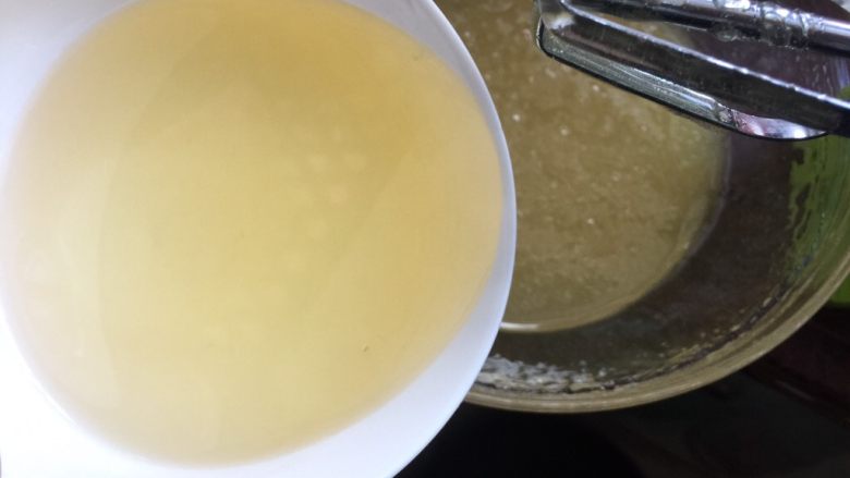 广式蛋黄红豆沙月饼,植物油分次加入转化糖浆中，用打蛋器搅拌均匀，每次吸收后再次加入油