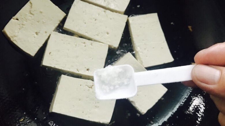 香煎豆腐,在豆腐的表面均匀的撒上盐。