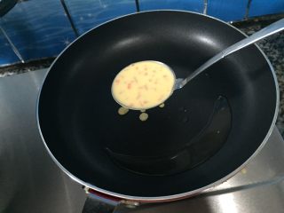 火腿胡萝卜鸡蛋饼,等油热一下后，就用汤勺把准备好的蛋粉糊慢慢的捣在锅上