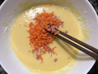 火腿胡萝卜鸡蛋饼,然后把火腿肠粒和胡萝卜粒倒入打好的蛋粉里面，进行顺时针的搅拌