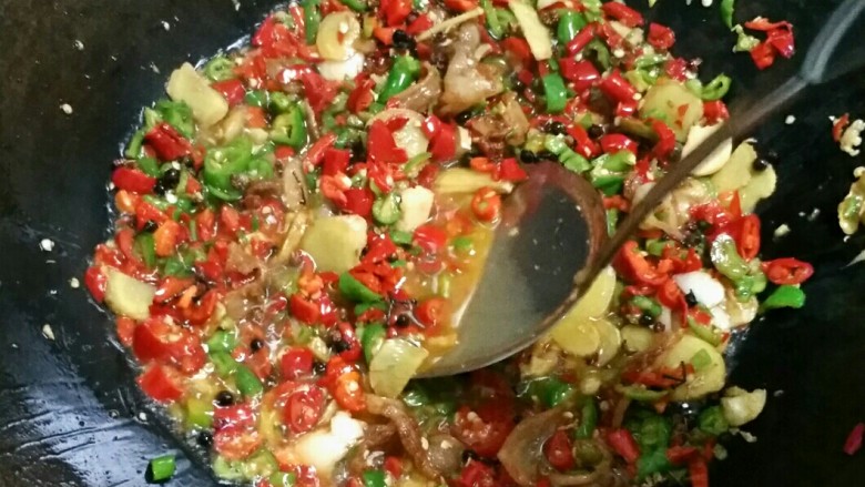 贵州风味鱼火锅,等辣椒炒出红油后继续煸炒2分钟。