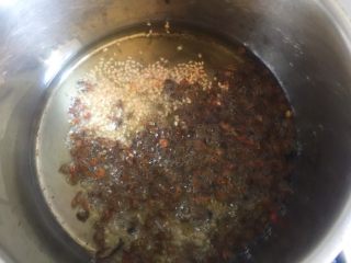 椒麻鸡,锅内放入玉米油烧至七成热后熄火，放入白芝麻、辣椒粉和麻椒粒。