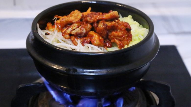 韩式五花肉拌饭,将石锅放在火上烧5分钟。