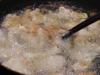炸酥肉,用筷子轻轻的翻动，让肉炸均匀，微微上色后捞出；让油继续烧热，再次放入肉复炸。