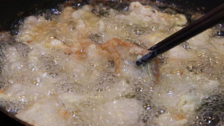 炸酥肉,用筷子轻轻的翻动，让肉炸均匀，微微上色后捞出；让油继续烧热，再次放入肉复炸。