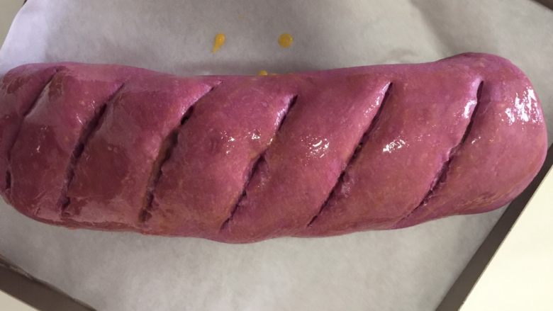 紫薯大列巴,发酵好后165度预热烤箱
在面包上割几道口子，深一点，以见到里面的馅为准
我用的刀不好，这回割不好…
擦点蛋液在表面