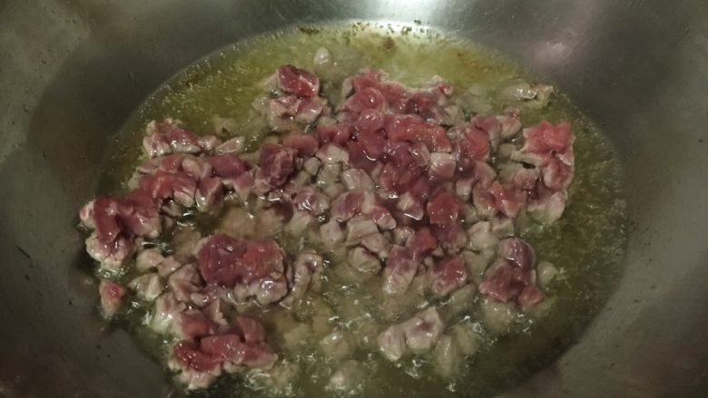 牛肉香菇酱,锅内放油烧至五成热，放入牛肉粒迅速翻炒。