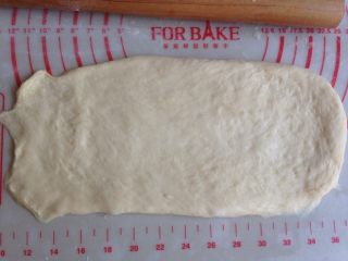 面包机版玉米香肠面包,翻面之后，擀成14CM*26CM的长方形，其中一条短边擀薄