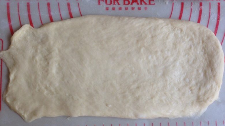 面包机版玉米香肠面包,翻面之后，擀成14CM*26CM的长方形，其中一条短边擀薄