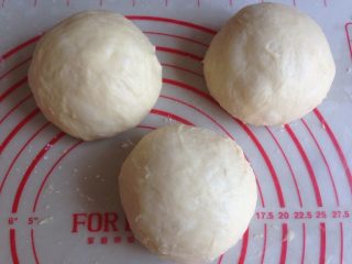 面包机版玉米香肠面包,面团排气，分成3等份，滚圆，盖上保鲜膜，松驰15分钟